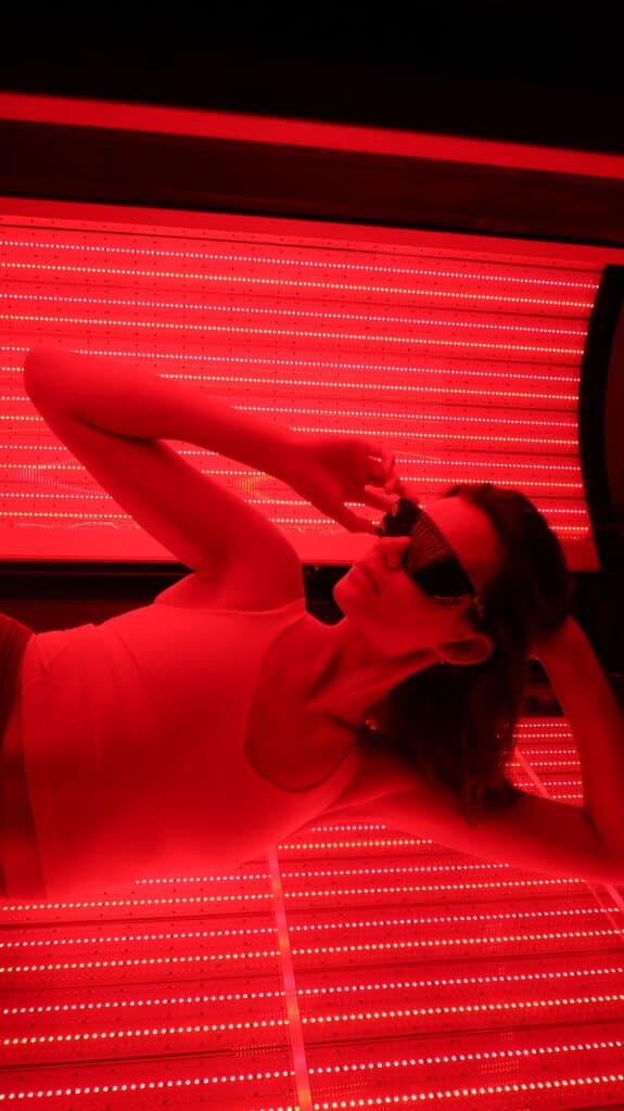 person in red light bed