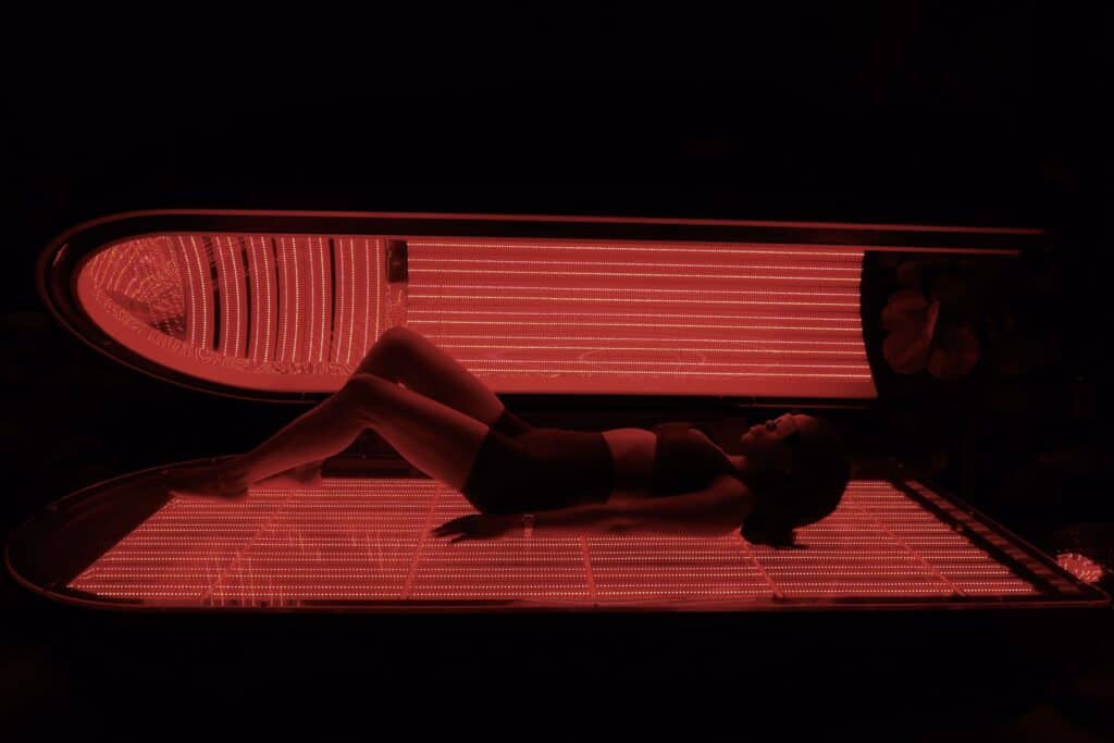 woman in red light chamber bed